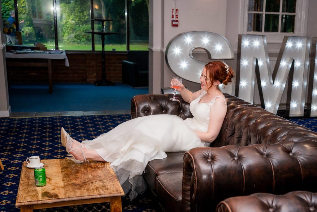A tired bride puts her feet up and takes a break from dancing at her wedding reception in RAF Henlow