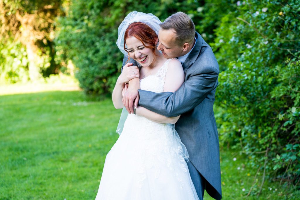 Bride and Groom cuddling in the grounds of RAF Henlow