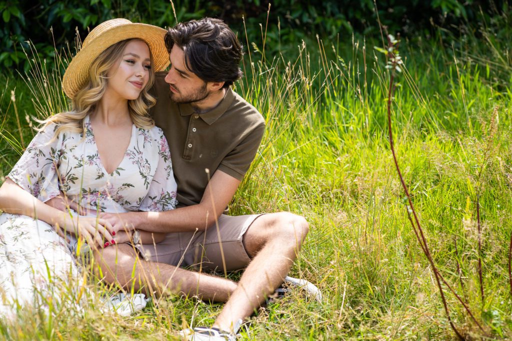 Engagement Photo Shoot of a couple sitting in the grass embracing
