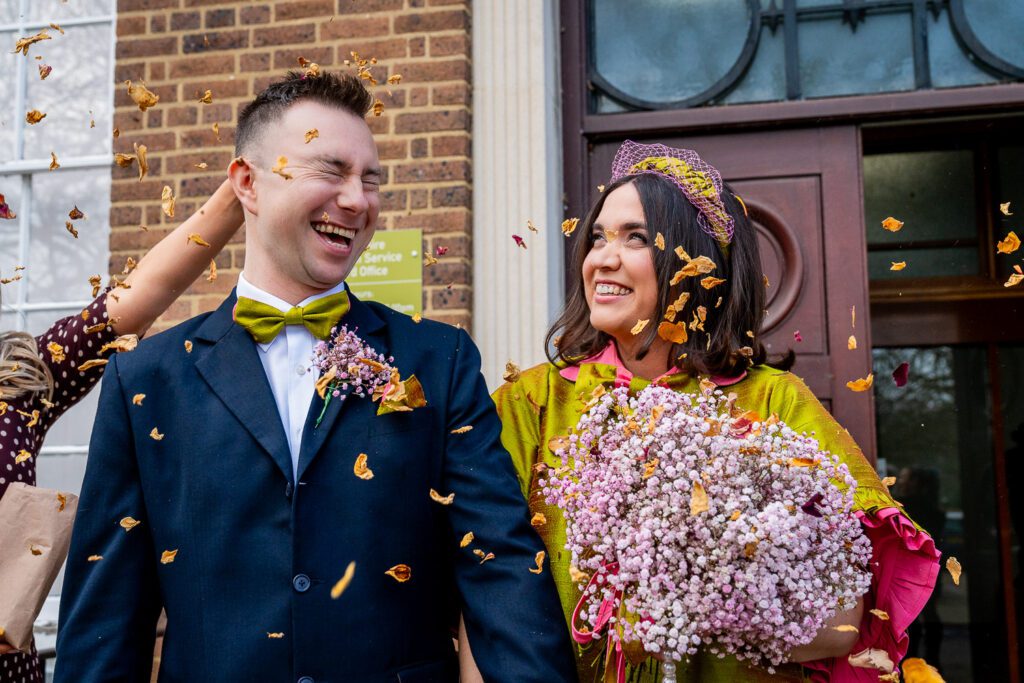 Bride and Groom having their confetti throw outside Hertford County Hall just after their wedding ceremony. Taken by Tim Payne Photography