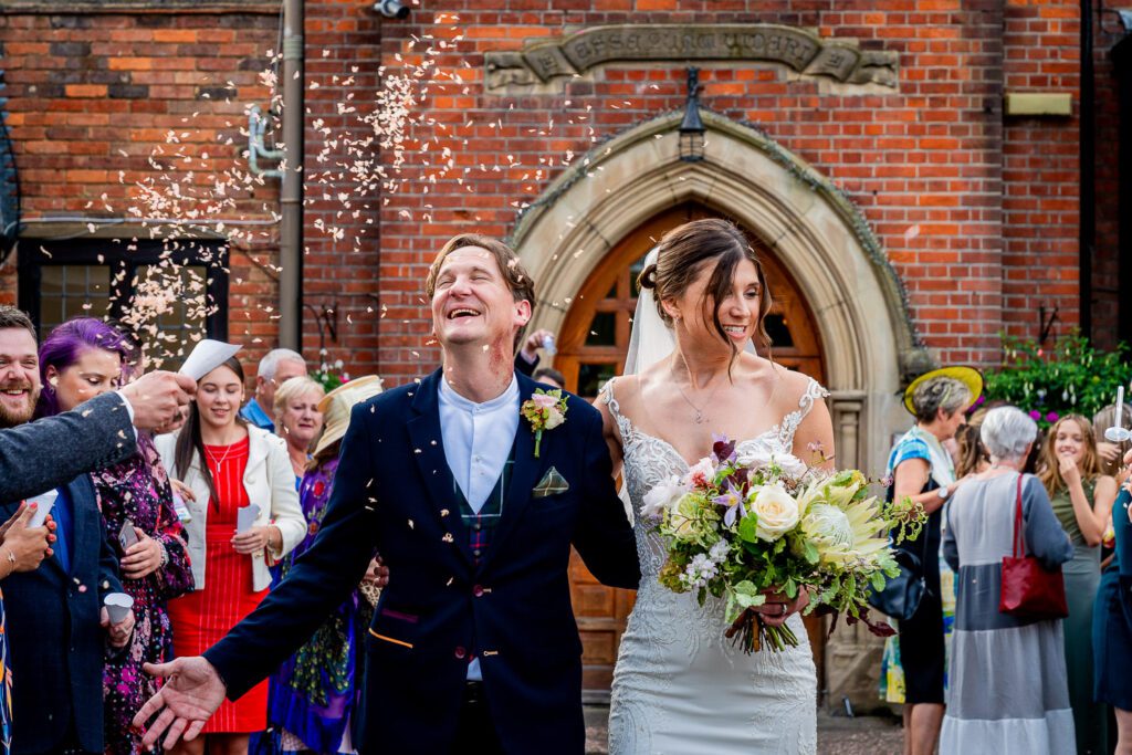 Bride and Groom with their confetti at Brickendon Grange. Taken by Tim Payne Photography, a Hertford wedding photographer