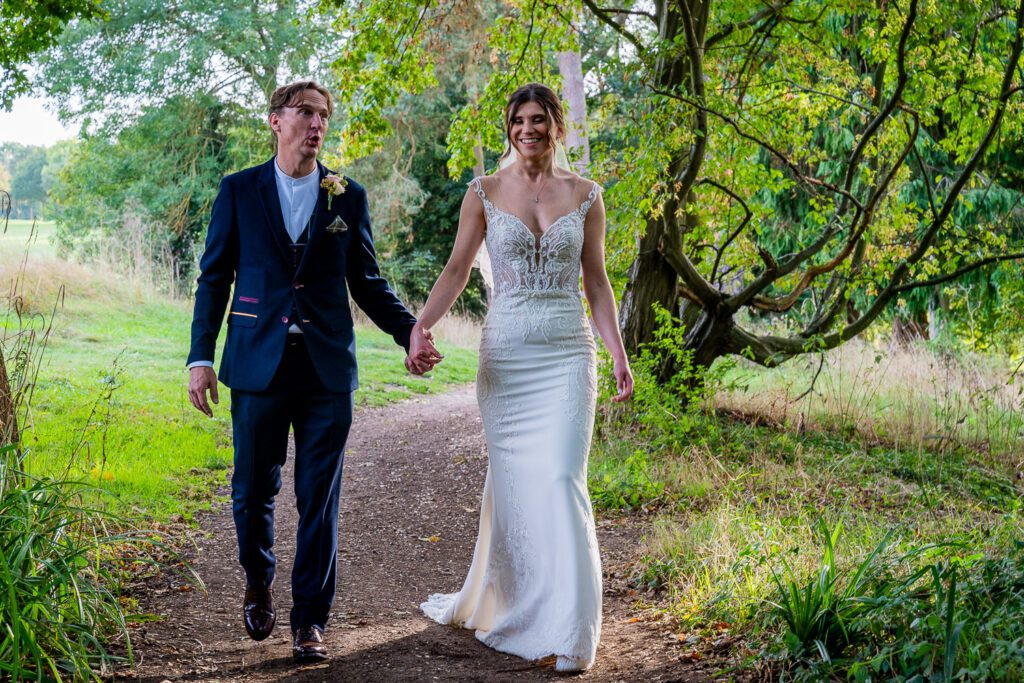 Bride and Groom holding hands in the grounds of Brickendon Grange . Taken by Tim Payne Photography