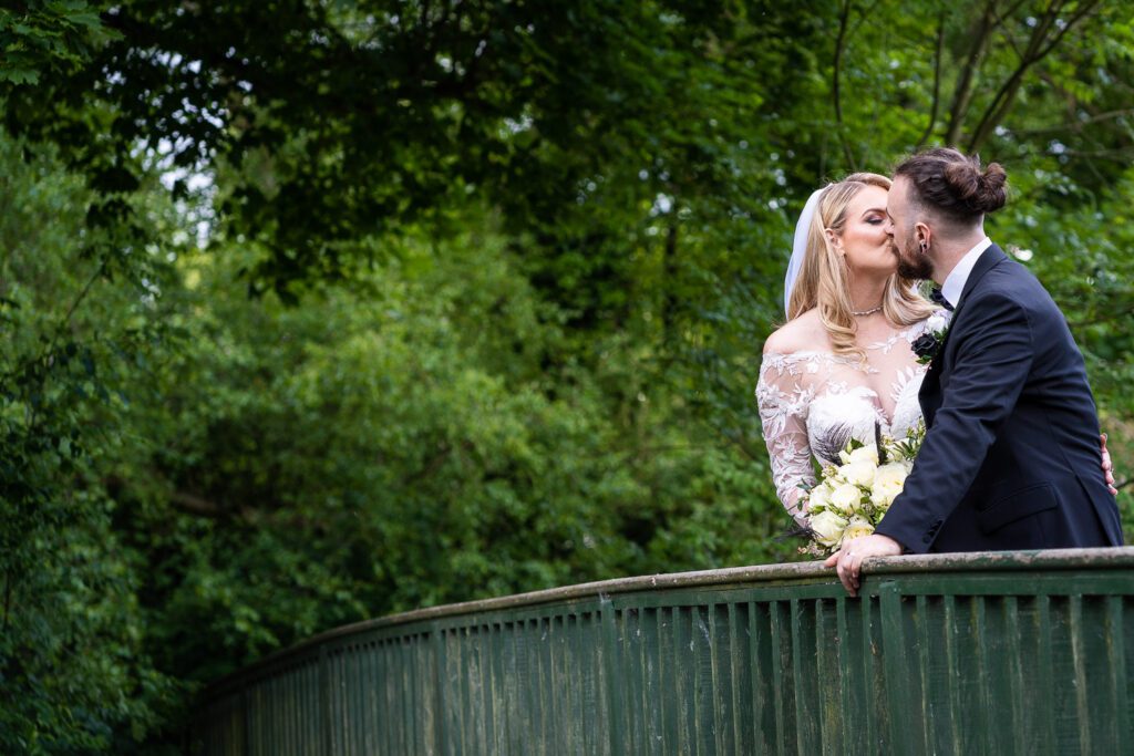 Newly married Bride and groom sharing a kiss in the grounds of Hertford Castle. Taken by Tim Payne a Hertfordshire wedding photographer