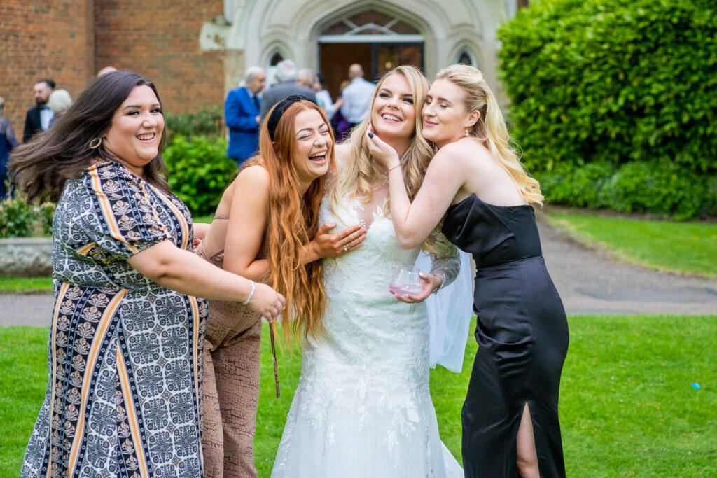 Bride and her bridesmaids having fun in the grounds of Hertford Castle. Taken by Tim Payne a Hertford wedding photographer