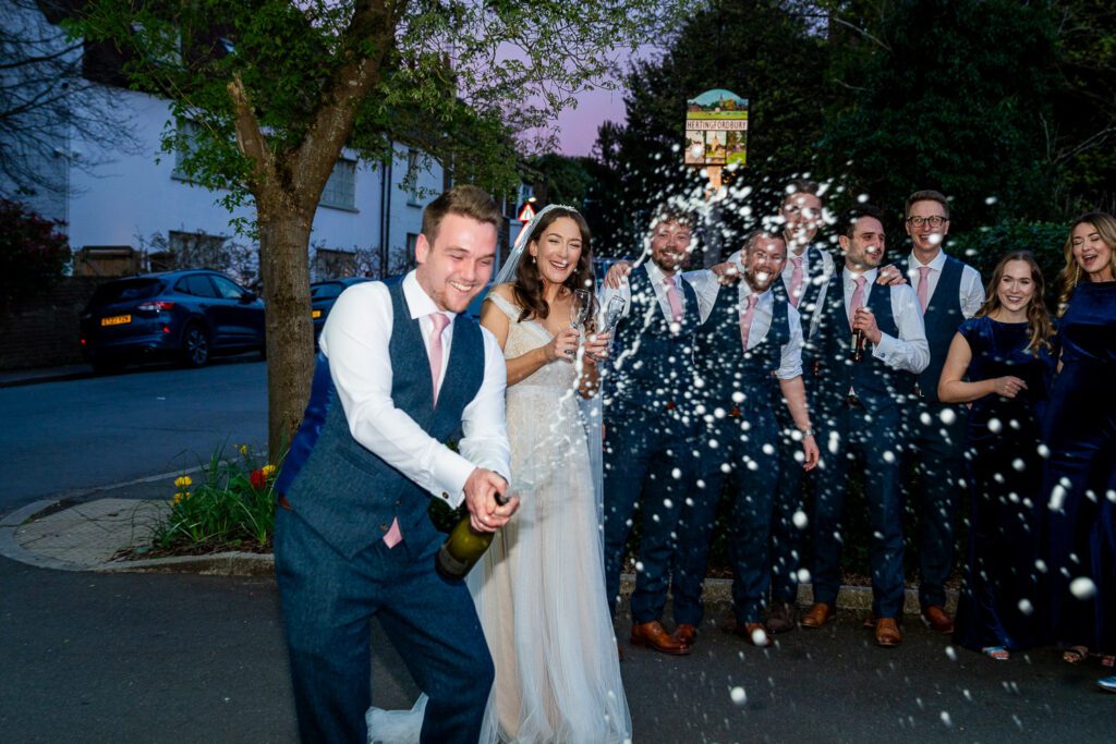 Bride and groom champagne spray at the White Horse, Hertingfordbury. Tim Payne Photography a Hertfordshire wedding photographer.