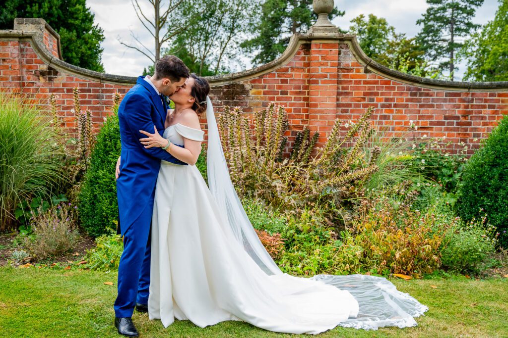 Bride and groom kissing in the grounds of Fanhams Hall, Ware. Tim Payne Photography a Hertfordshire wedding photographer