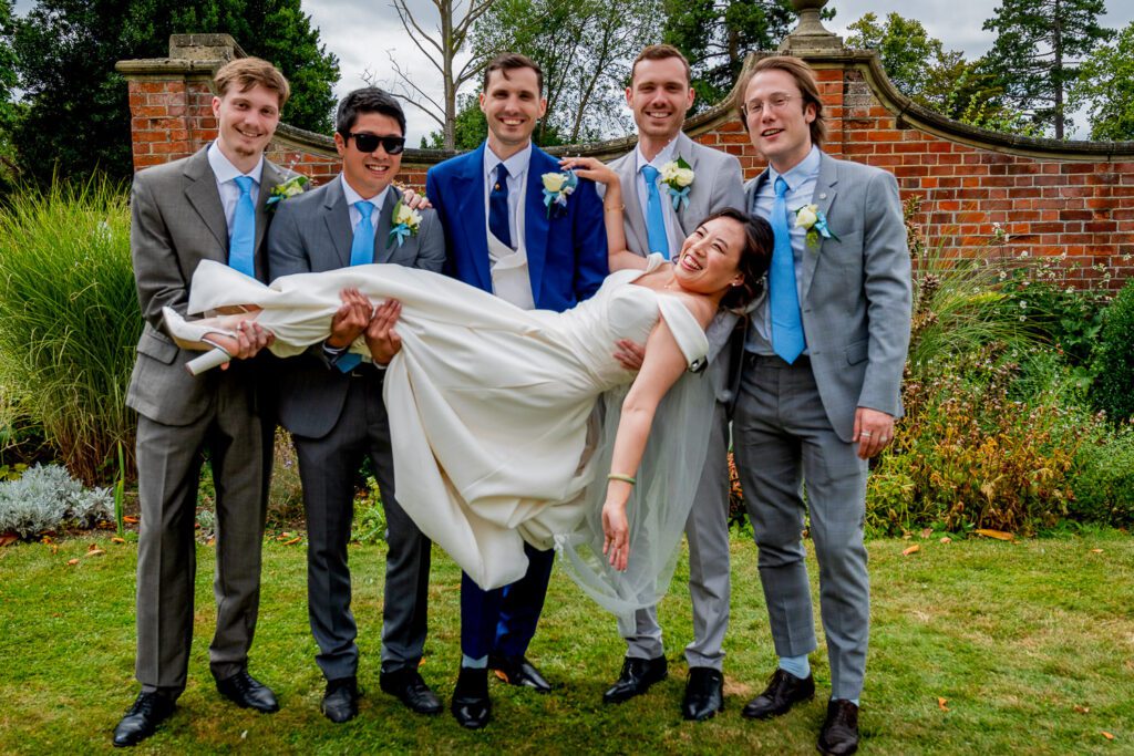 Bride being carried by the Groomsmen at Fanhams Hall, Ware. Tim Payne Photography a Hertford wedding photographer