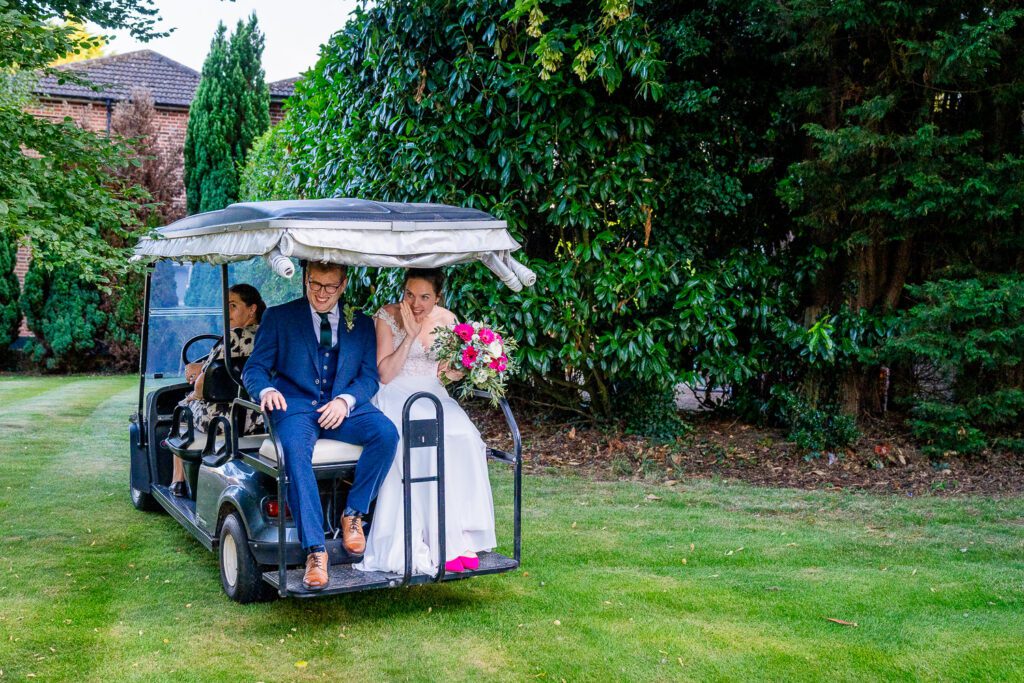 Bride and Groom sitting on a golf buggy at Essendon country club. Tim Payne photography, a Hertfordshire based wedding photographer