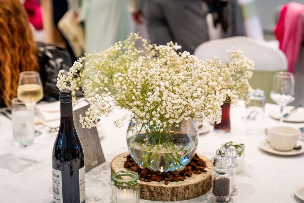 Close up of table decoration, a bowl filled with dainty white flowers called Gypsophila on a laid table