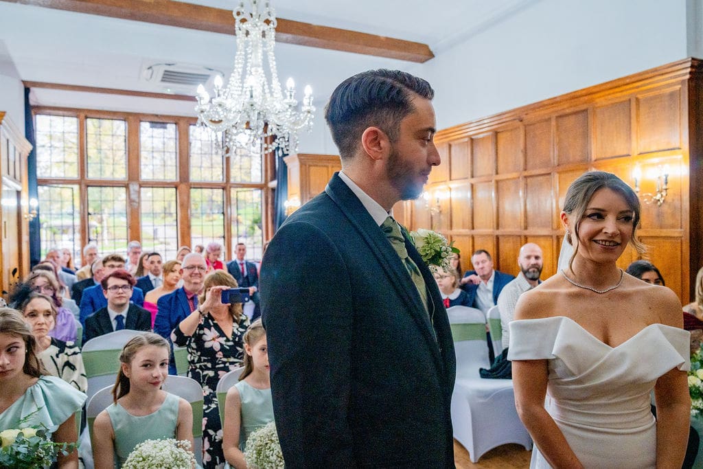 Bride and groom with guests in the Oak panel ceremony room at Brickendon Grange wedding venue