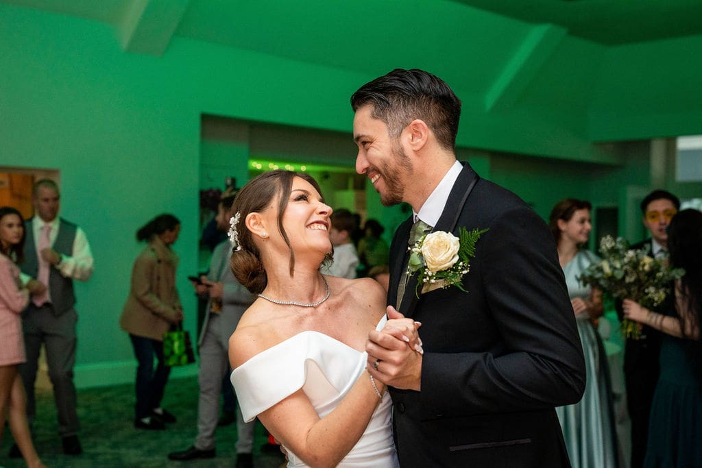 Bride and Groom's 1st dance, they are looking into each other's eyes as guests watch on