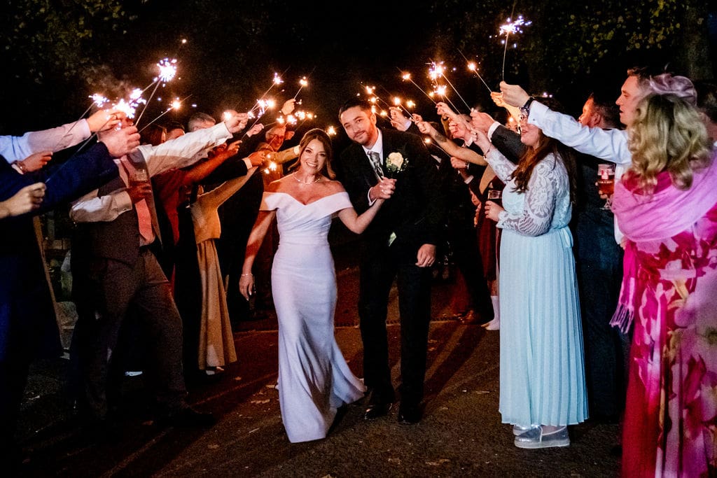 Iit's dar, a bridal couple walk through a guard of honour formed by guests with sparklers