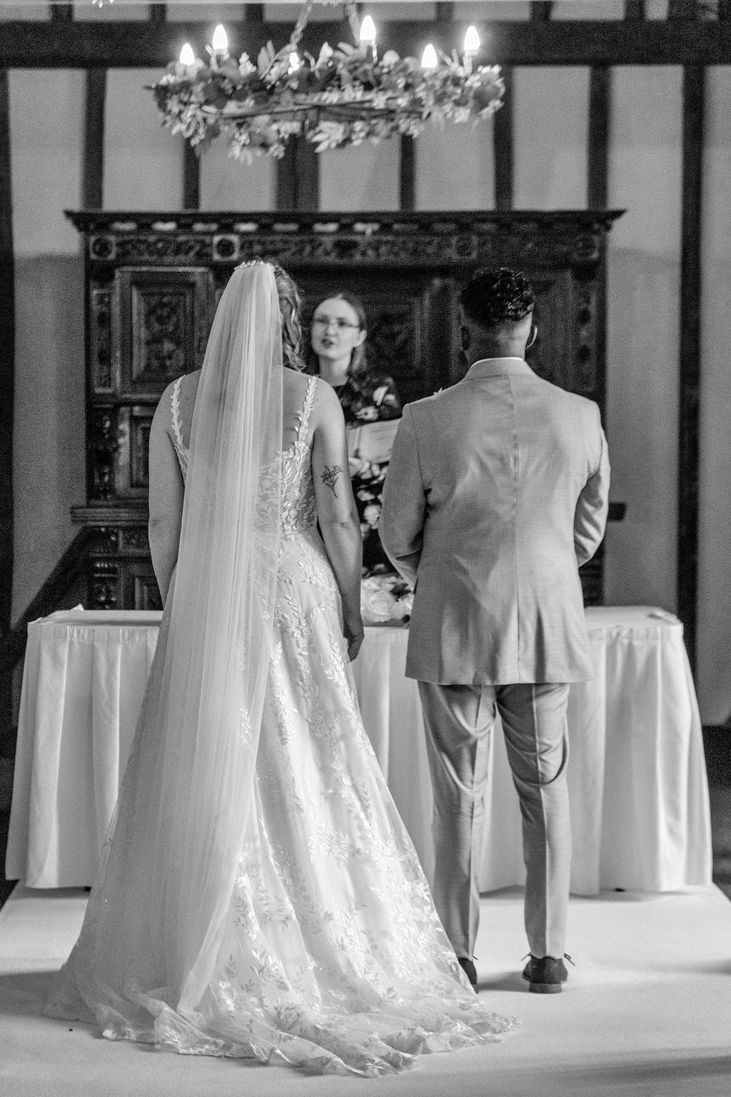 Essendon Country Club wedding venue black and white of the backs of a bride and groom facing the registrar during their wedding ceremony