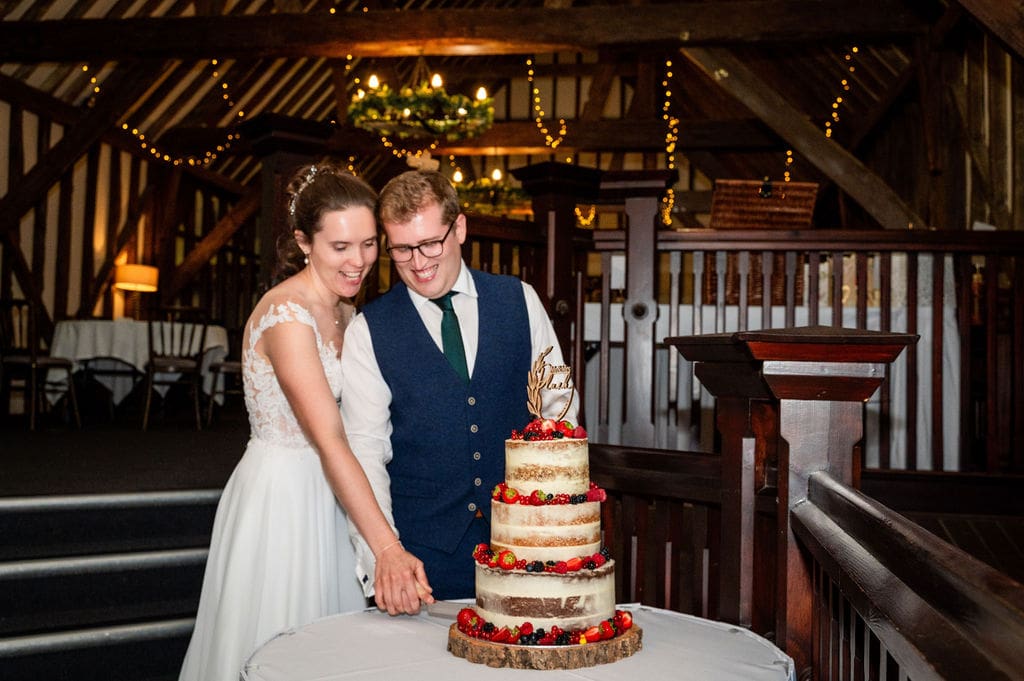 Essendon Country Club wedding venue, the dark stairacse leading ot the mezzanine flow, where a traditional bride and groom are cutting their wedding cake