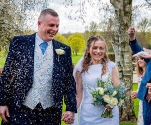 Ask your wedding photographer blog - a bride and groom being showered in confetti